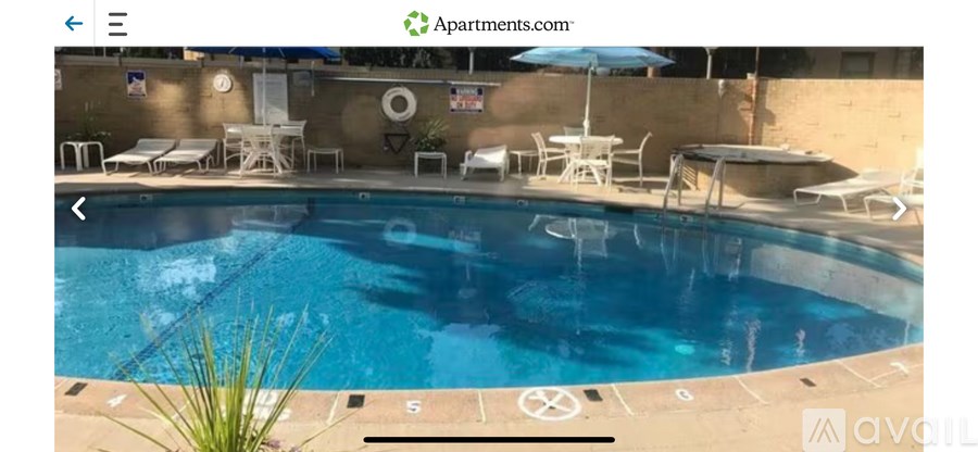 A pool with chairs and umbrellas around it.