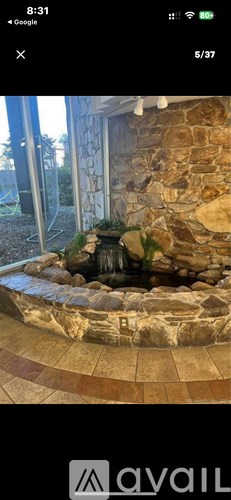 A stone fountain in the middle of a tiled patio.