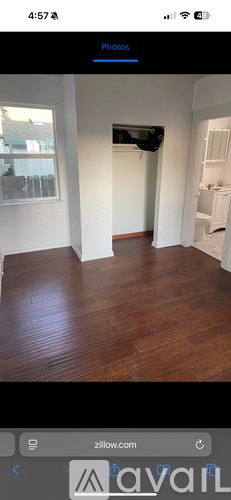 A room with wooden flooring and white walls.
