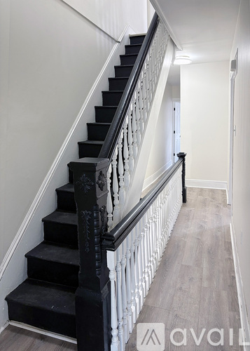 A staircase with black steps and white railings.