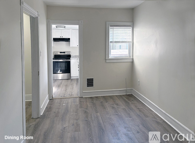 A dining room with a kitchen in the background.