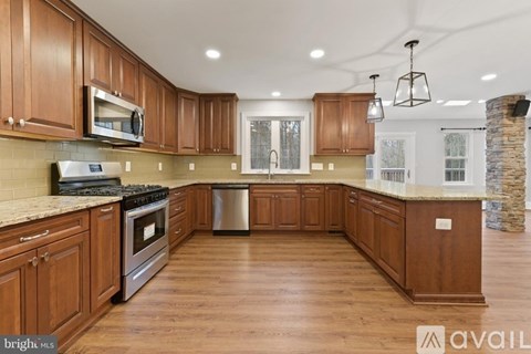 A kitchen with wooden cabinets and a stone fireplace.