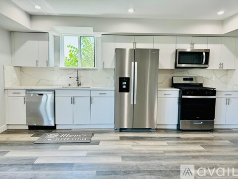 A modern kitchen with stainless steel appliances and white cabinets.