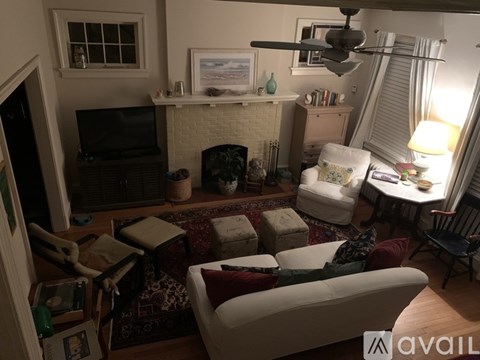 A living room with a white couch and a fireplace.