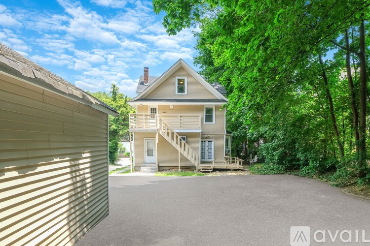 A house with a driveway and trees in the background.