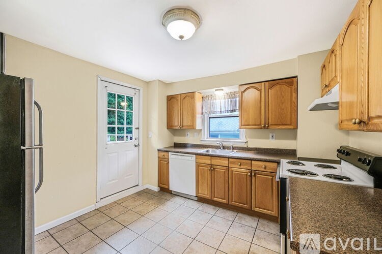A kitchen with wooden cabinets and a black refrigerator.