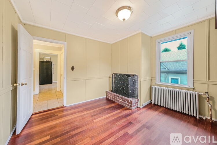 A room with wooden floors and a brick fireplace.