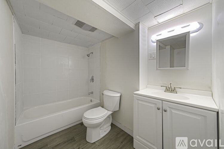 A white bathroom with a toilet, sink, and bathtub.