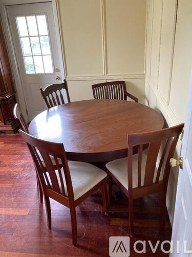 A wooden dining table with four chairs around it.