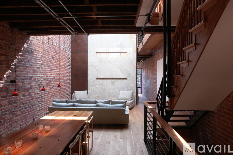 A living room with a brick wall and a couch.