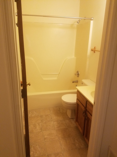 A bathroom with a toilet, sink and shower.