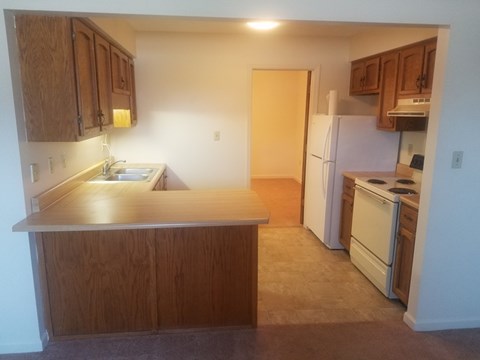 A kitchen with wooden cabinets and a white refrigerator.
