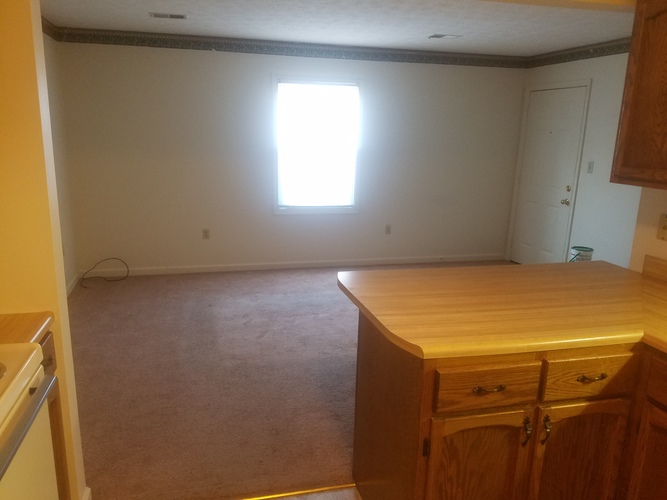A room with a window and a wooden desk.