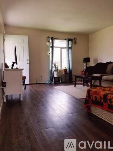 A living room with a couch, chair, and a table with a lamp.