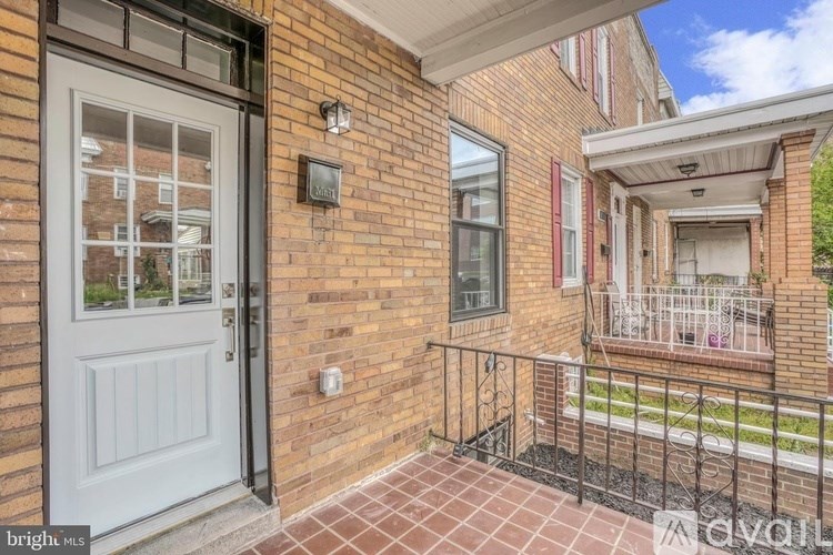 A brick house with a white door and a balcony.