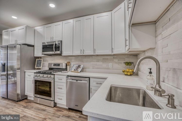 A kitchen with white cabinets and stainless steel appliances.