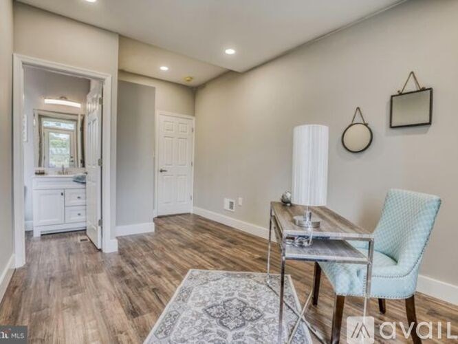 A room with a wooden floor and a white chair.