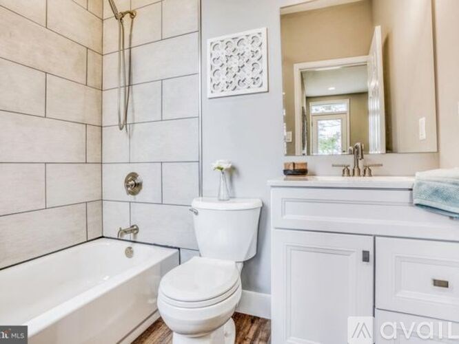 A white toilet sits next to a bathtub in a bathroom.