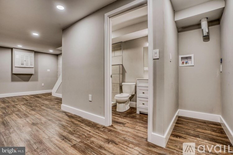 A bathroom with a toilet, sink, and mirror.