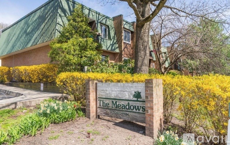 A sign that says "The Meadows" in front of a building.
