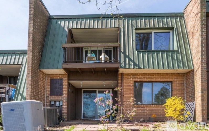 A modern house with a balcony and a green roof.