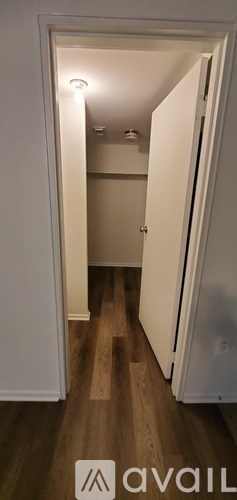 A hallway with wooden floors and white walls.