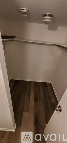 A small room with a wooden floor and a white door.