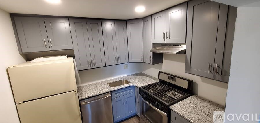 A kitchen with a refrigerator, dishwasher, and stove top oven.