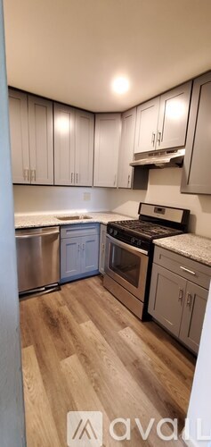 A kitchen with wooden floors and white cabinets.