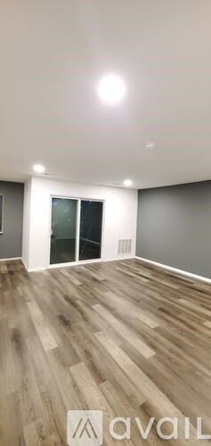 A room with wooden flooring and a white ceiling with a light fixture.