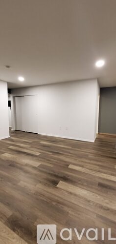 A room with wooden flooring and white walls.
