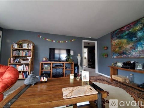 A living room with a wooden coffee table and a red chair.