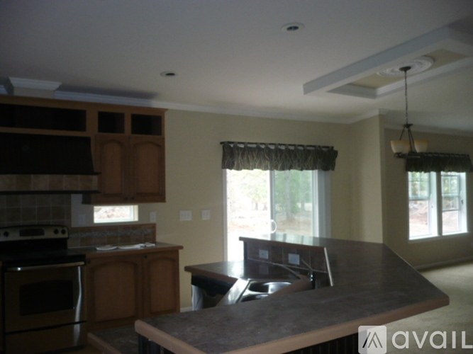 A kitchen with a granite countertop and wooden cabinets.