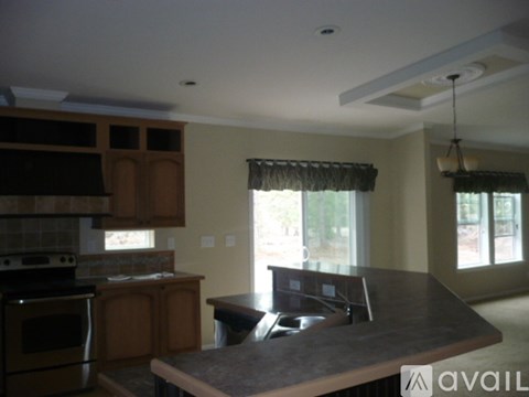 A kitchen with a granite countertop and wooden cabinets.
