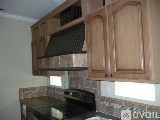 A kitchen with wooden cabinets and a black stove top.