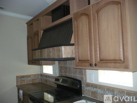 A kitchen with wooden cabinets and a black stove top.