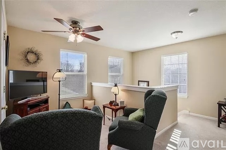 A living room with a television, two chairs, and a table.