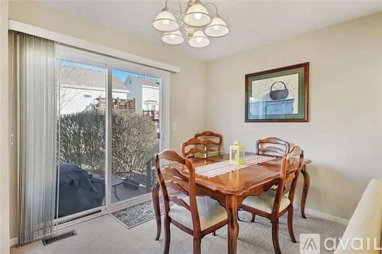 A dining room with a wooden table and chairs.