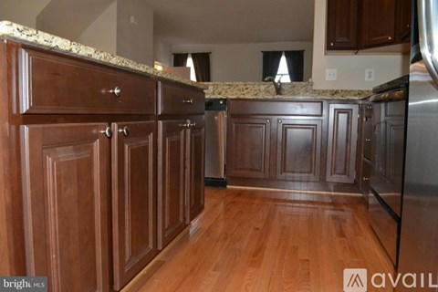 A kitchen with wooden cabinets and a granite countertop.