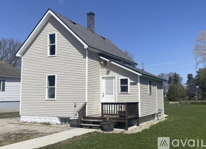 A house with a porch and a chimney is available for sale.