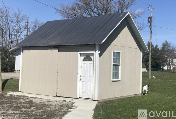 A dog is standing in front of a small house.