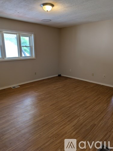 A room with wooden flooring and a window.