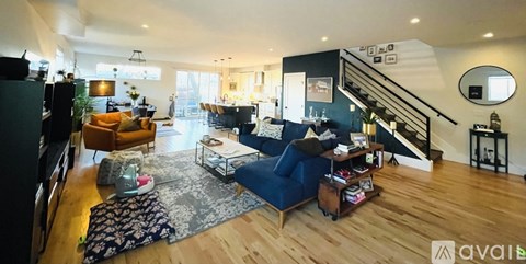 A living room with a blue couch and a wooden floor.