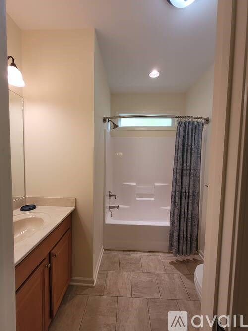 A bathroom with a sink, mirror, and bathtub.