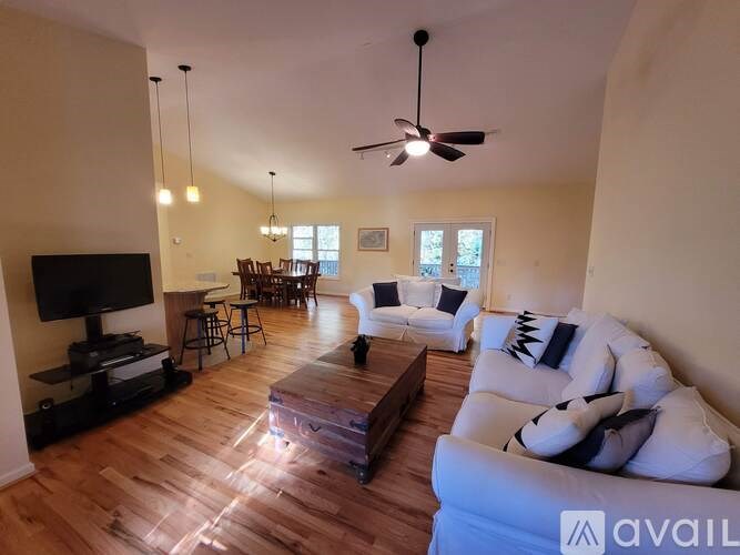 A living room with a white couch and a wooden coffee table.