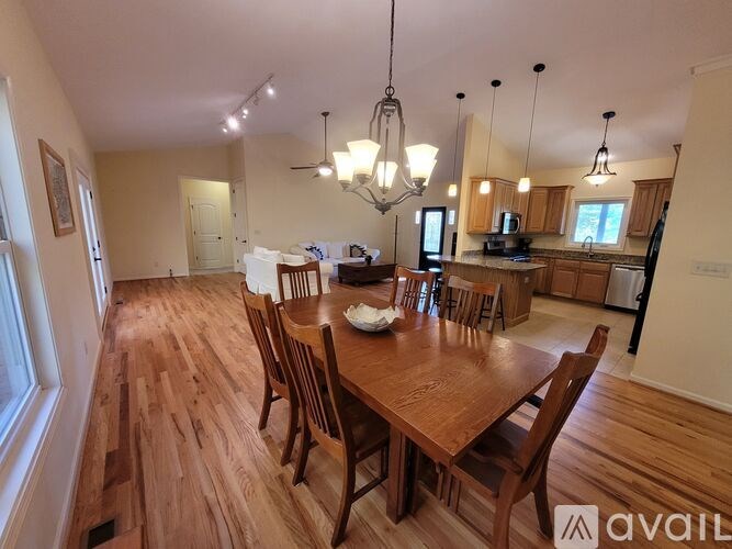 A dining room with a wooden table and chairs.