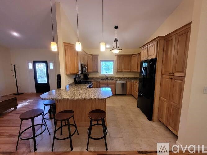 A kitchen with a bar area and wooden cabinets.