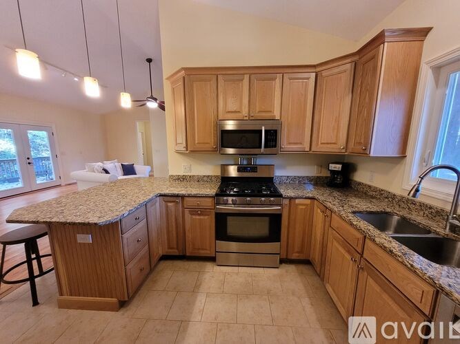 A kitchen with wooden cabinets and granite countertops.