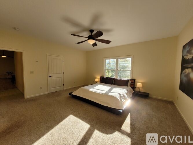 A bedroom with a large bed and a ceiling fan.