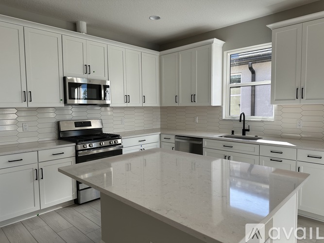 A kitchen with white cabinets and a large island.